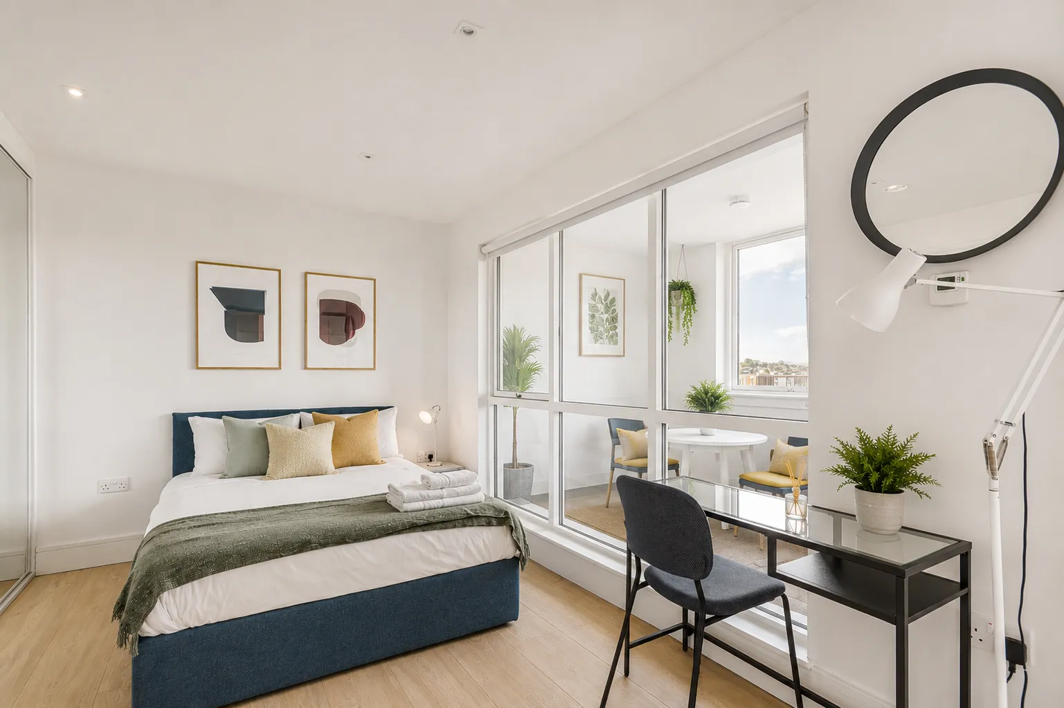 Double bedroom with a desk, mirrored partition and framed prints, in a one-bedroom flat at Vonder Wembley