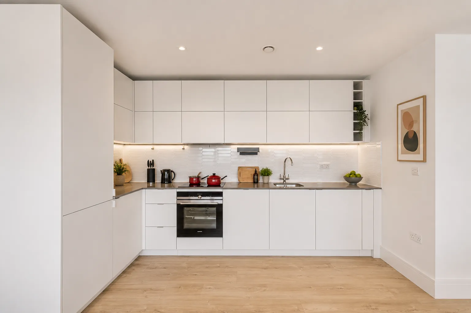 Fitted kitchen with integrated oven and hob in a one-bedroom flat at Vonder Wembley