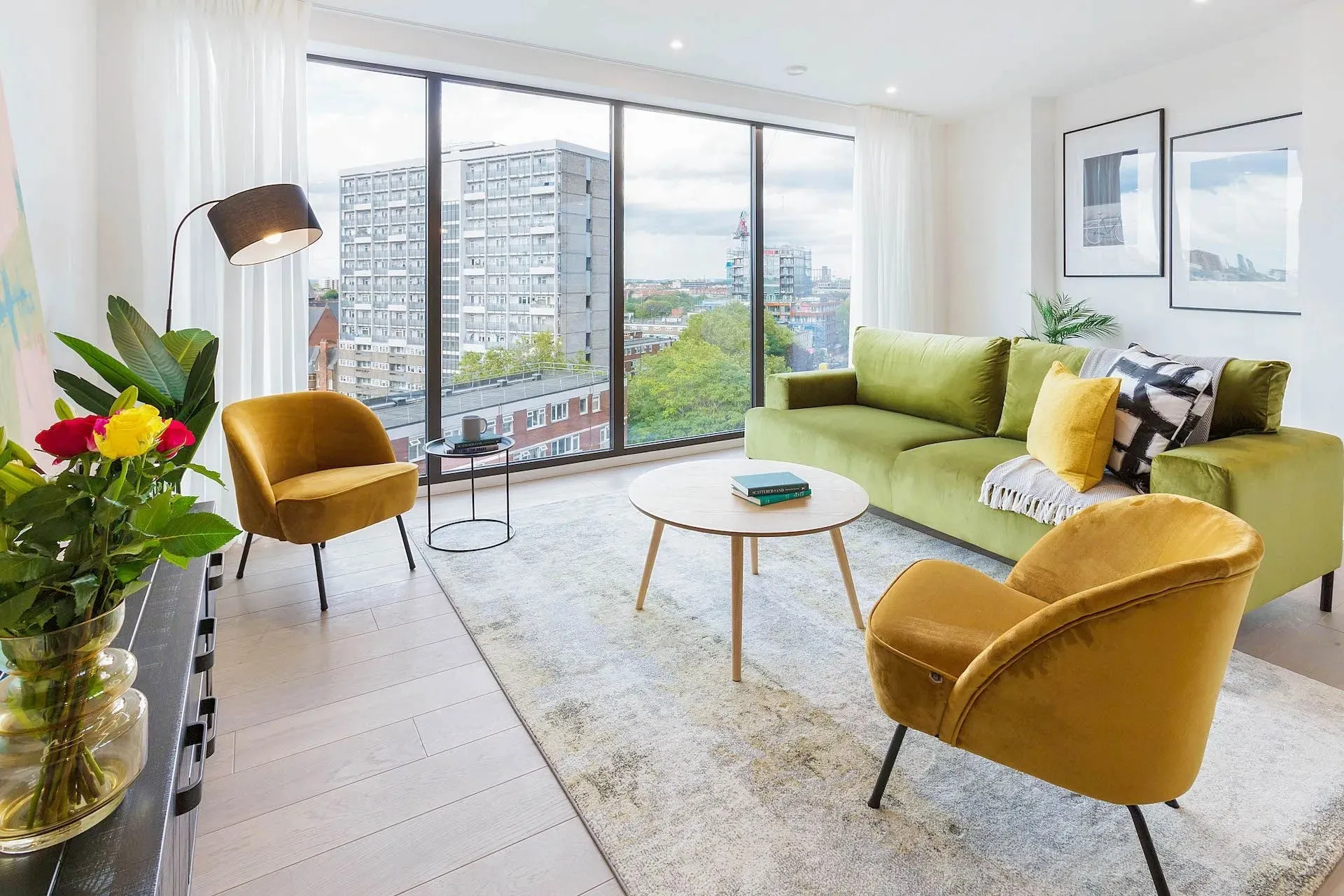 Bright living area with mustard armchairs and a city view in a Vonder apartment in London