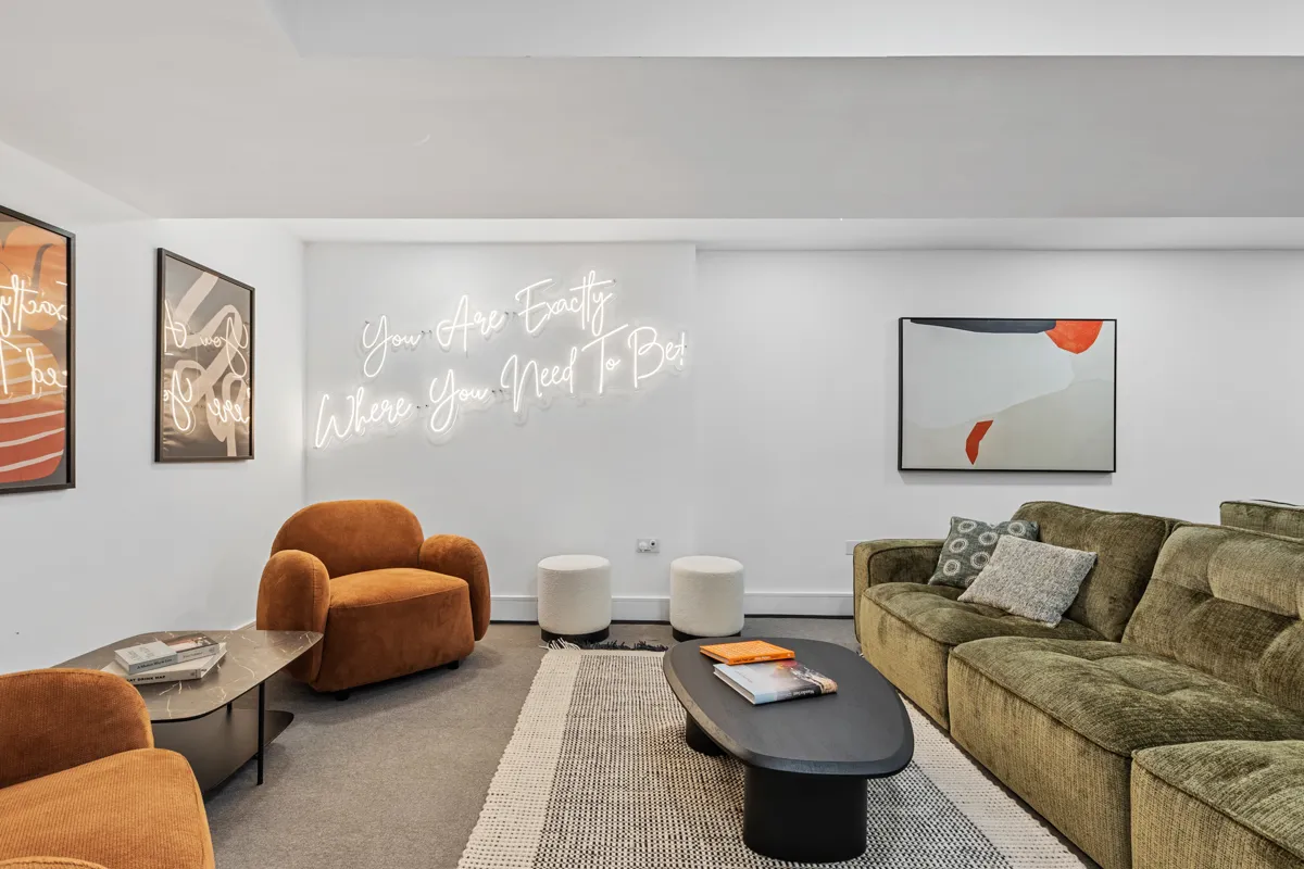 Lounge with armchairs and neon sign at Vonder Akron House
