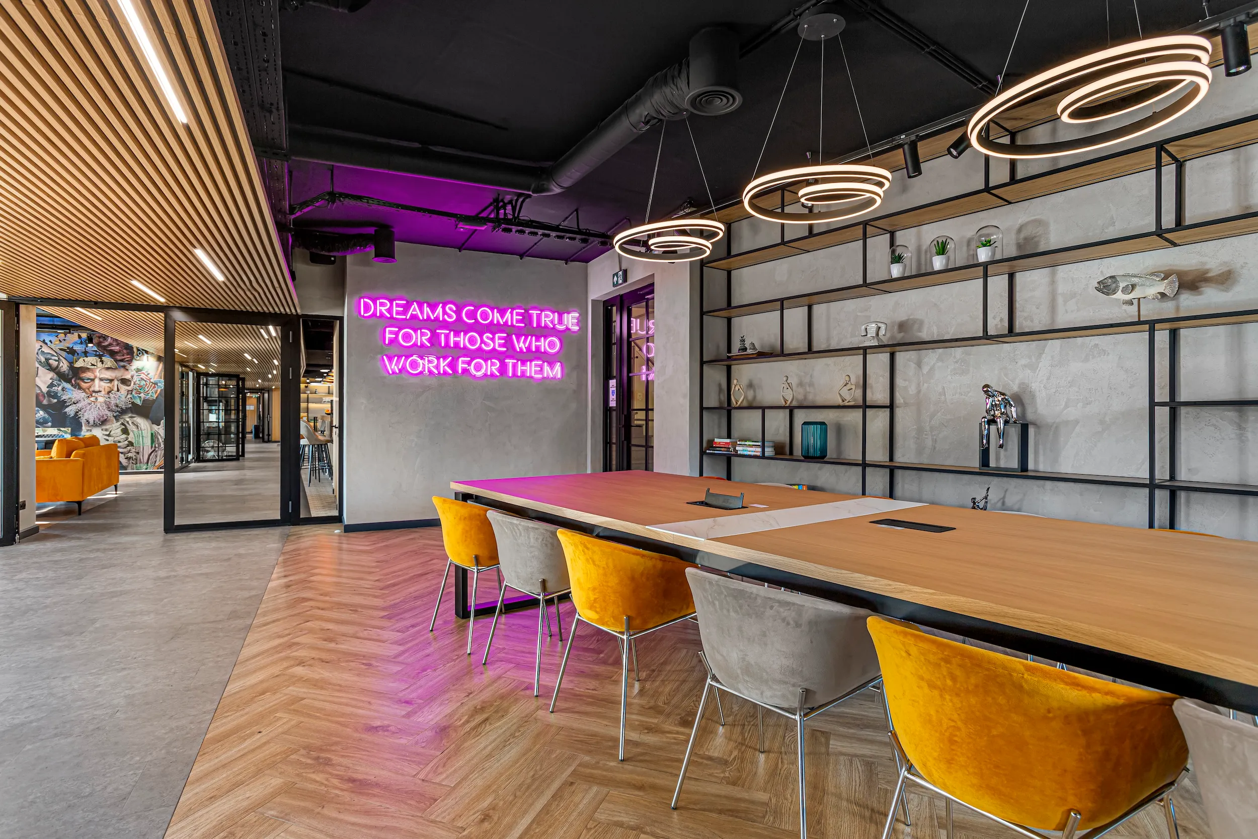 Co-working table at Vonder Upriver with yellow chairs and a pink neon sign