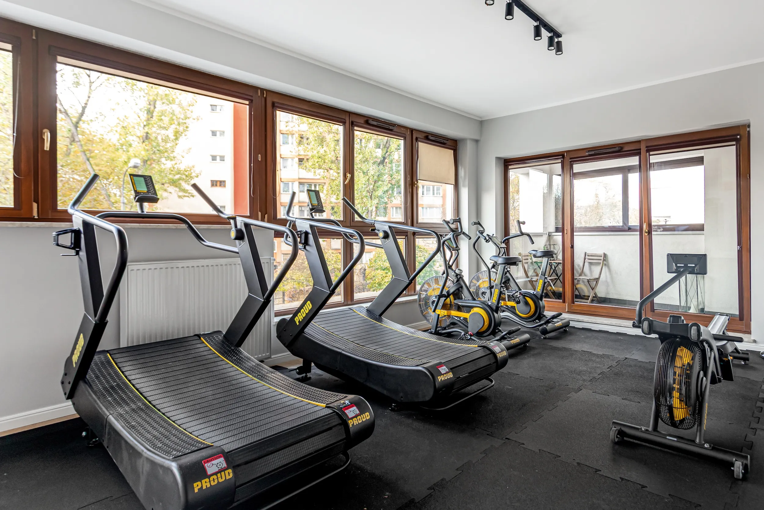 Cardio area of the Vonder Upriver gym with treadmills and exercise bikes by large windows