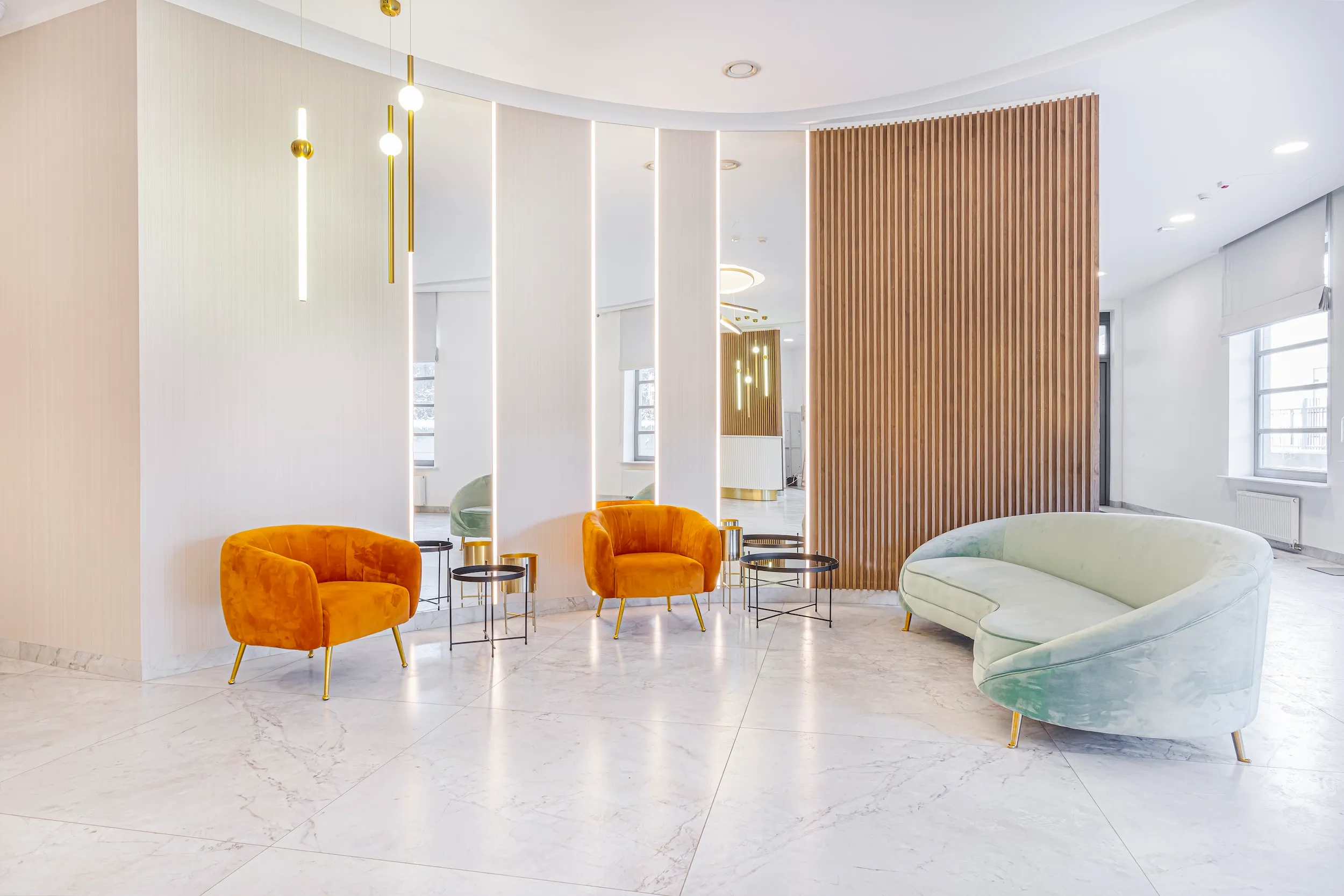 Lobby seating area at Vonder Upriver with orange armchairs and a curved sofa