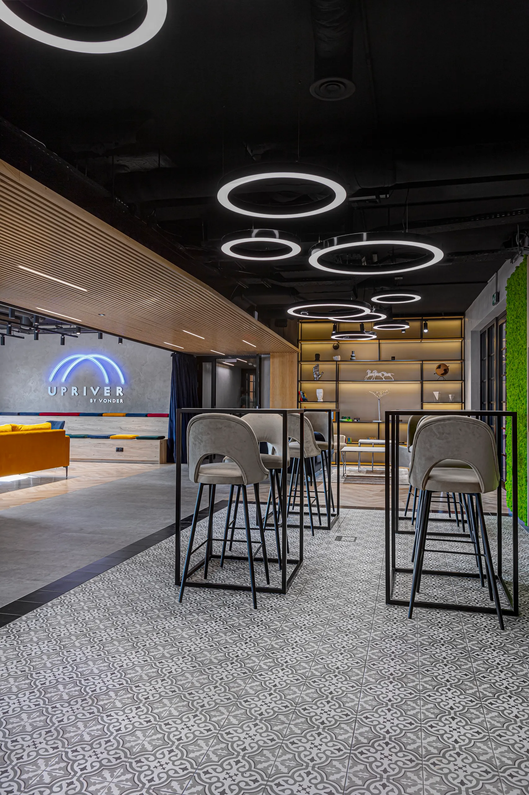 Lounge at Vonder Upriver with high bar tables under circular ceiling lights