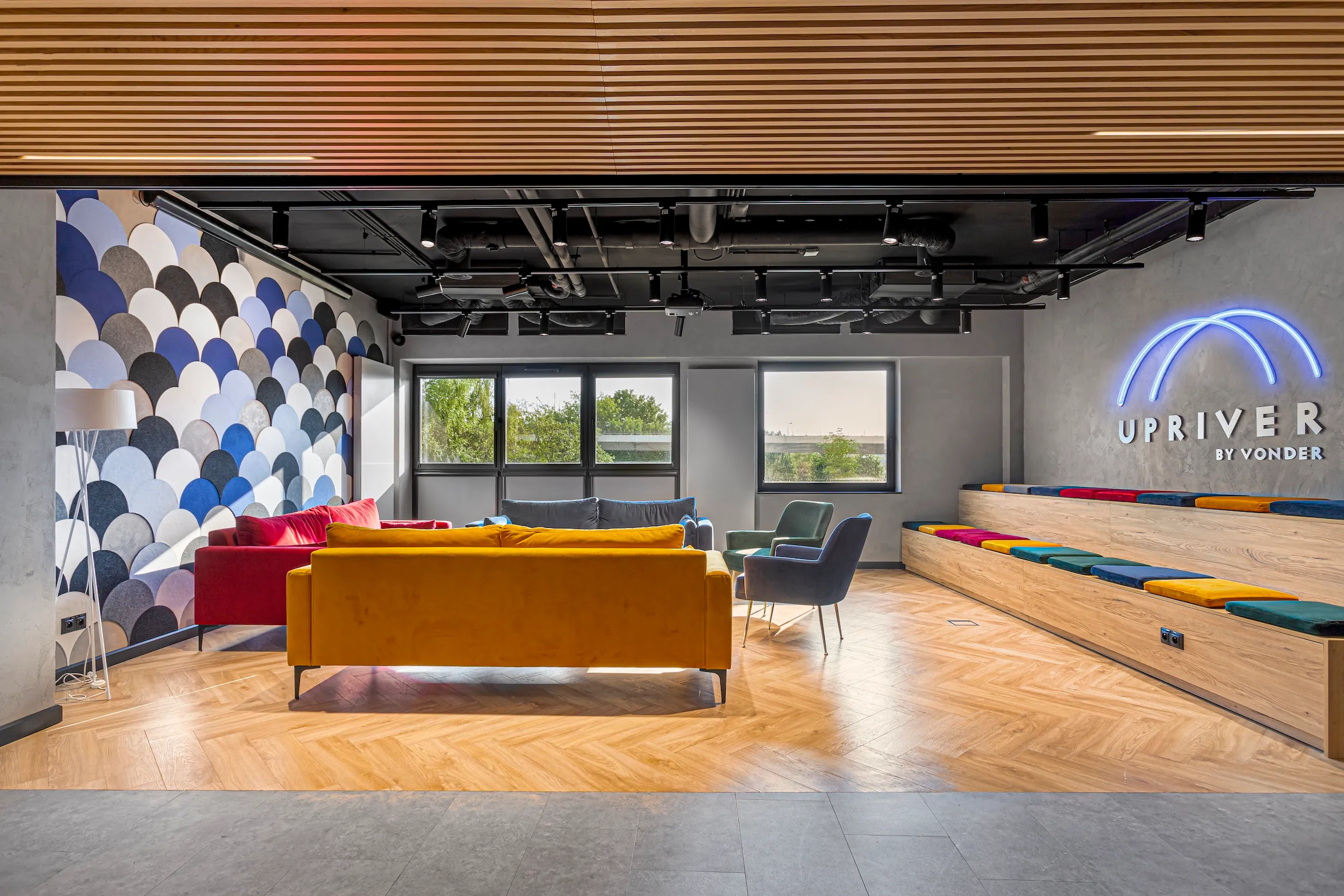 Upriver lounge with a mustard sofa, cushioned bench seating and a patterned feature wall