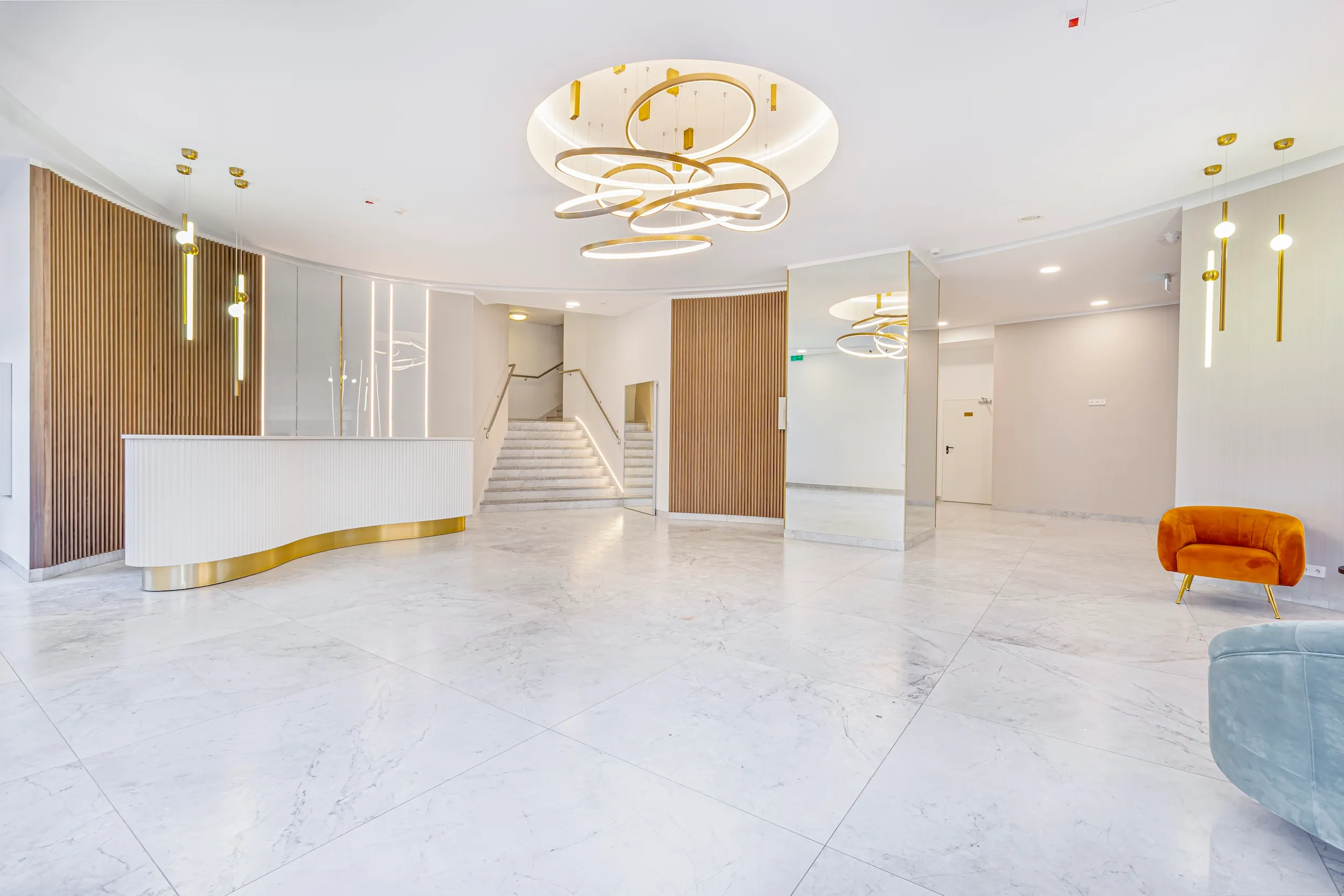 Bright marble reception lobby at Vonder Upriver with a front desk and sculptural ceiling light