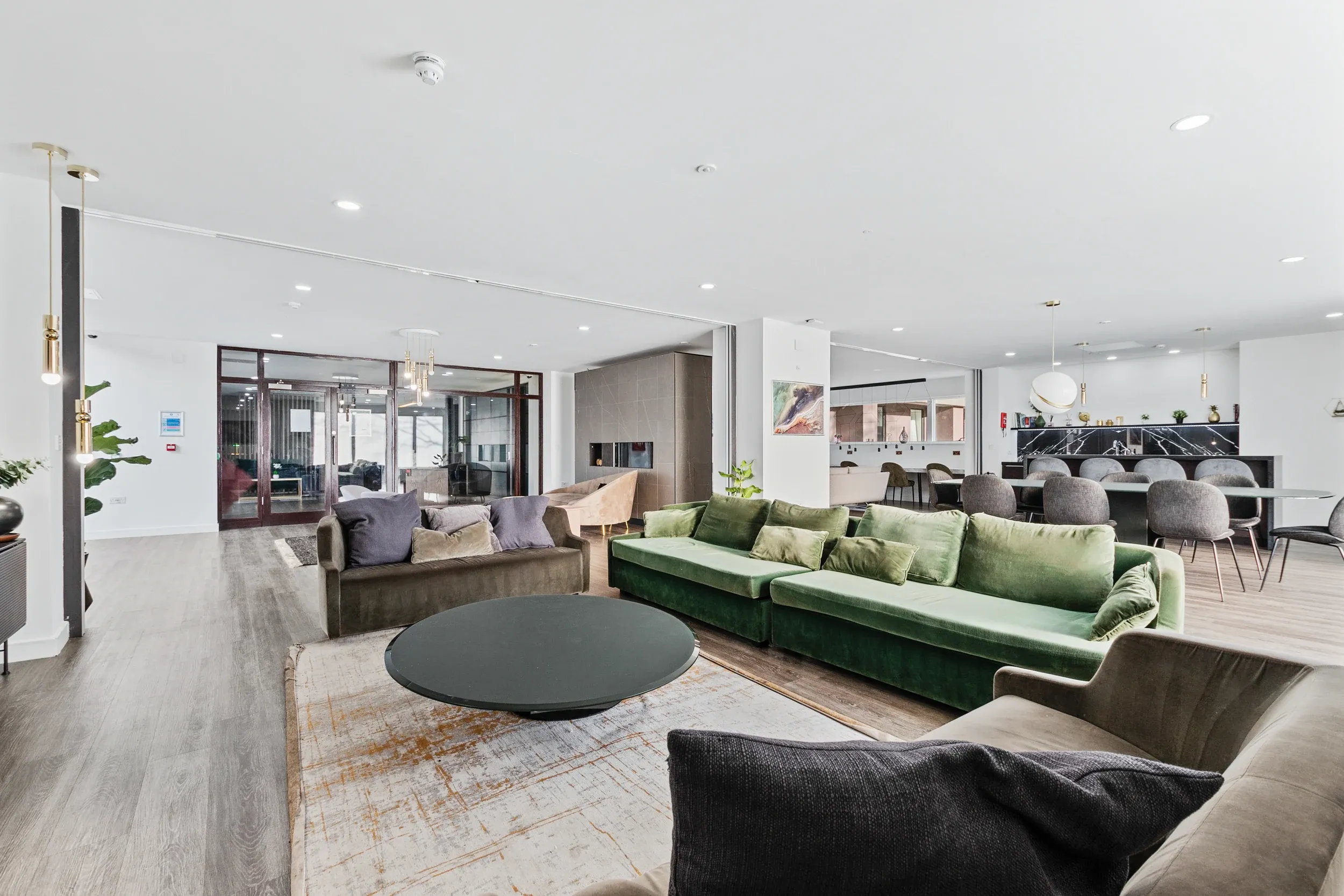 Lounge at Vonder Crawley, with a green sofa and the co-working desks behind
