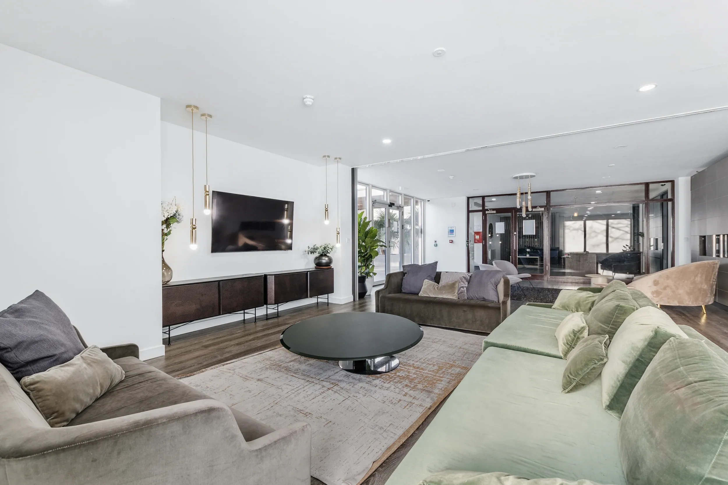 Media lounge at Vonder Crawley, with deep sofas facing a wall-mounted screen