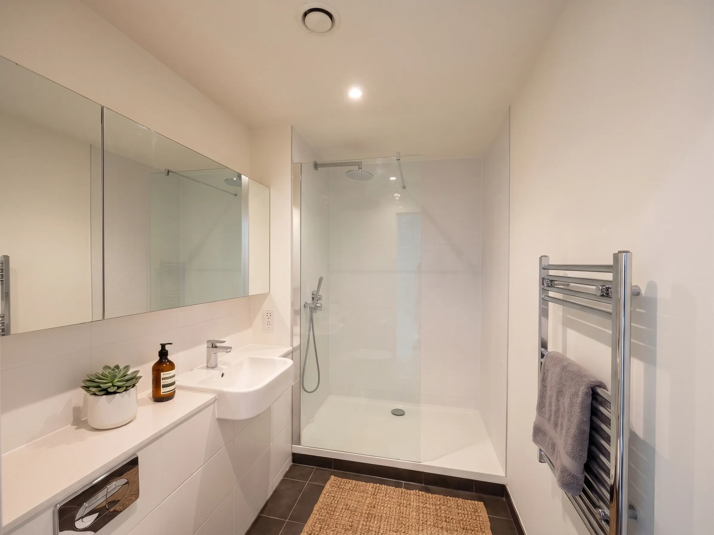 Bathroom in a studio flat at Vonder Crawley, with a walk-in shower, basin and heated towel rail