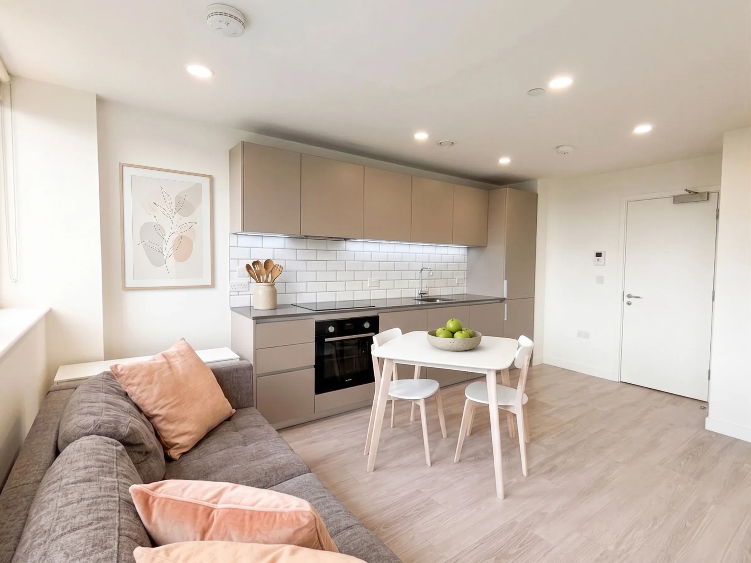 Living area and fitted kitchen in a studio flat at Vonder Crawley, with a dining table for two