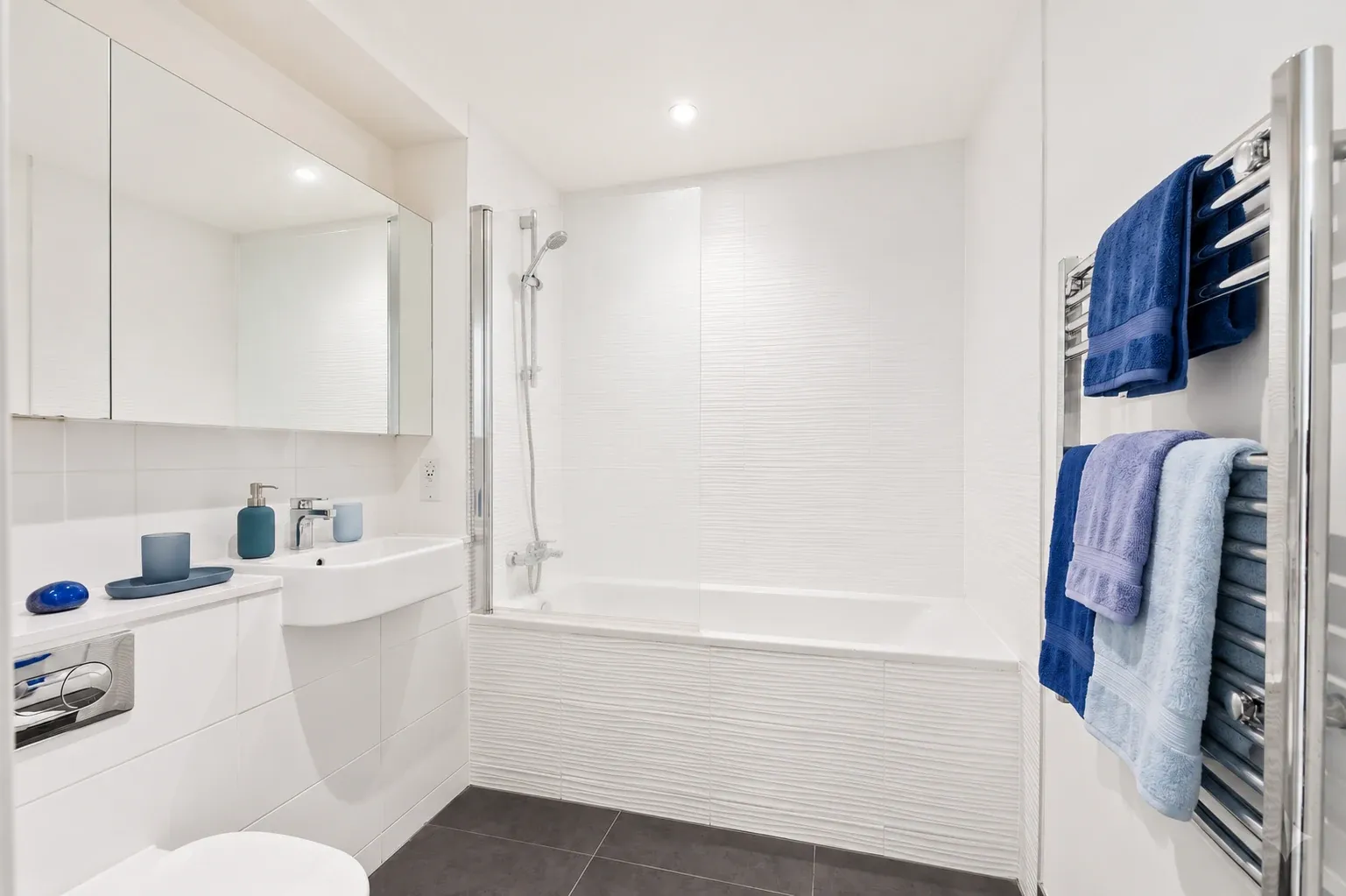Bathroom in a one-bedroom flat at Vonder Crawley, with a mirrored cabinet and heated towel rail