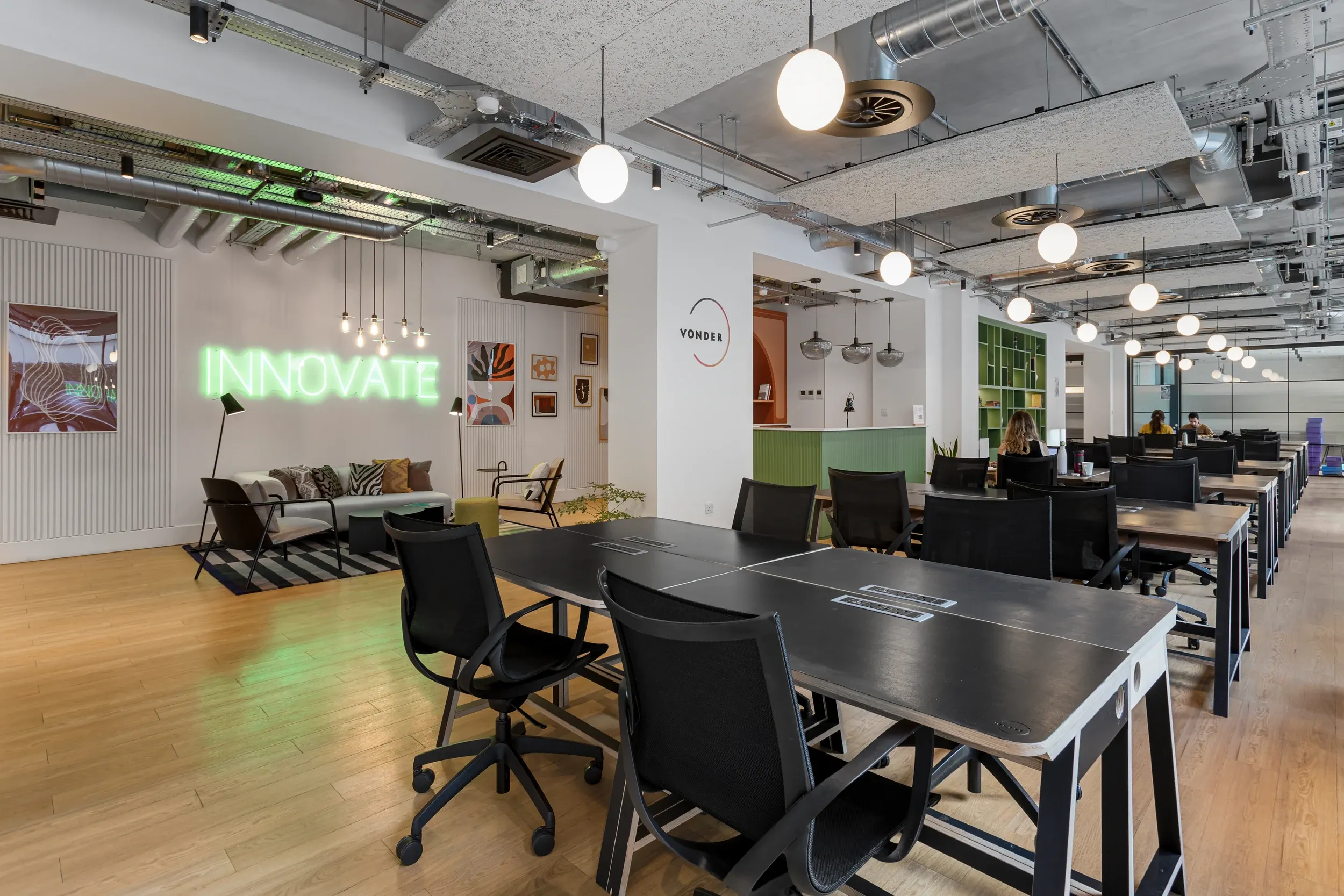 Co-working space at Vonder Wembley, with long shared desks and an exposed ceiling