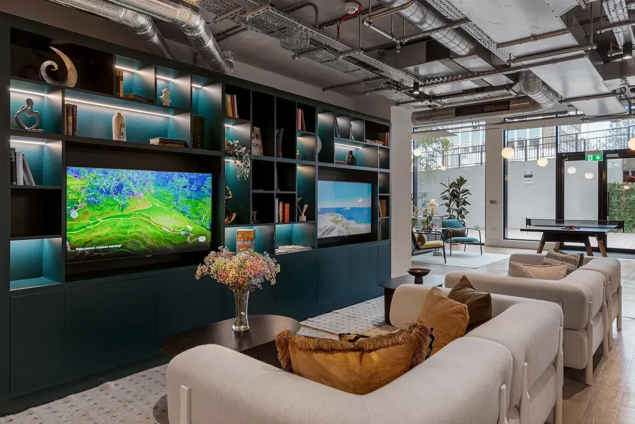 Media lounge at Vonder Wembley with a large screen, sofas and built-in shelving
