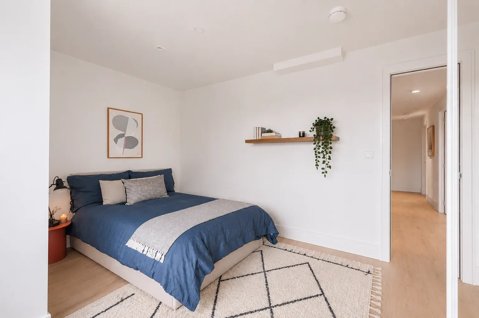Double bedroom with a floating shelf and framed print, looking through to the hallway, at Vonder Wembley