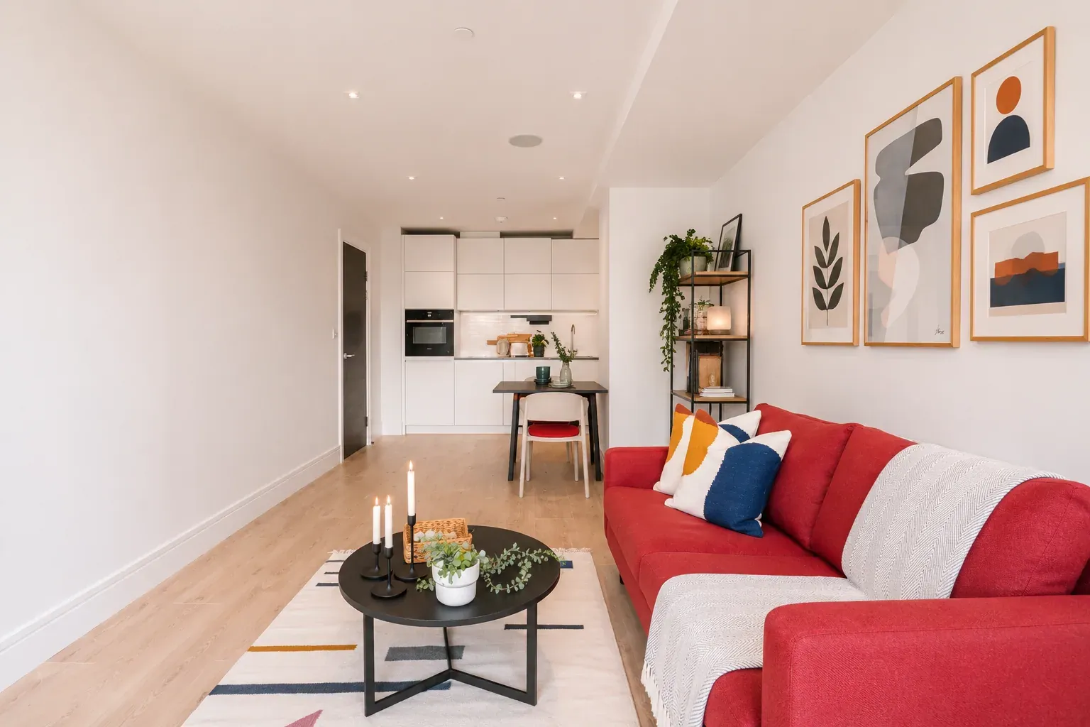 Living room looking towards the open-plan kitchen and dining table in a one-bedroom flat at Vonder Wembley